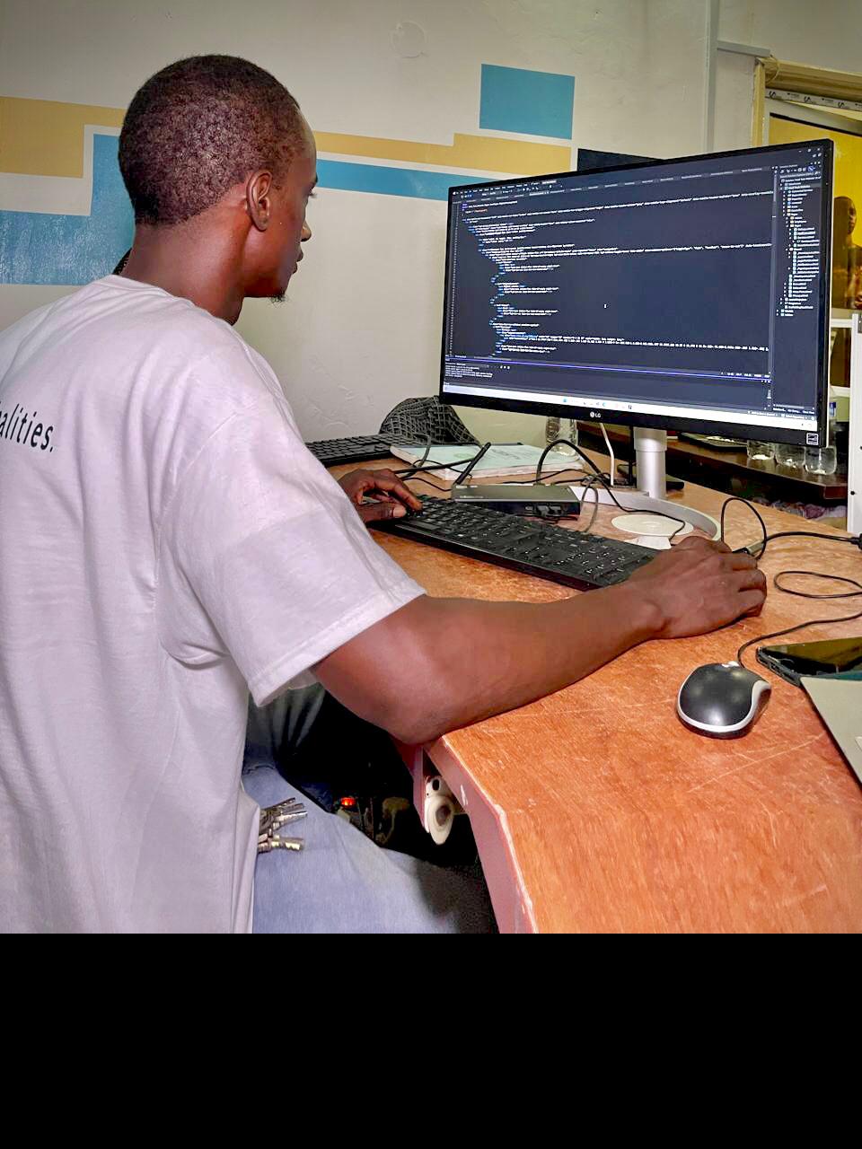 A Hadi Technologies developer working at a desktop with a code editor open